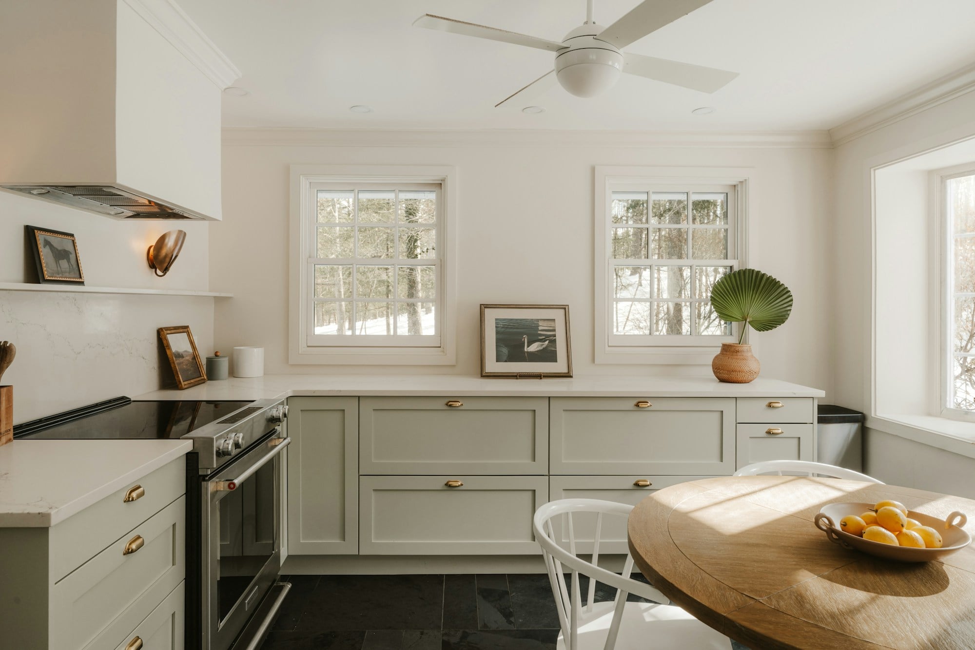 A bright kitchen with pale cabinets and a wooden table