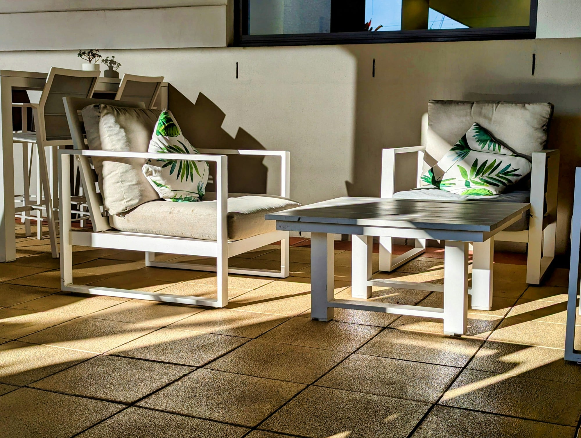 Two chairs and a small table on a covered patio