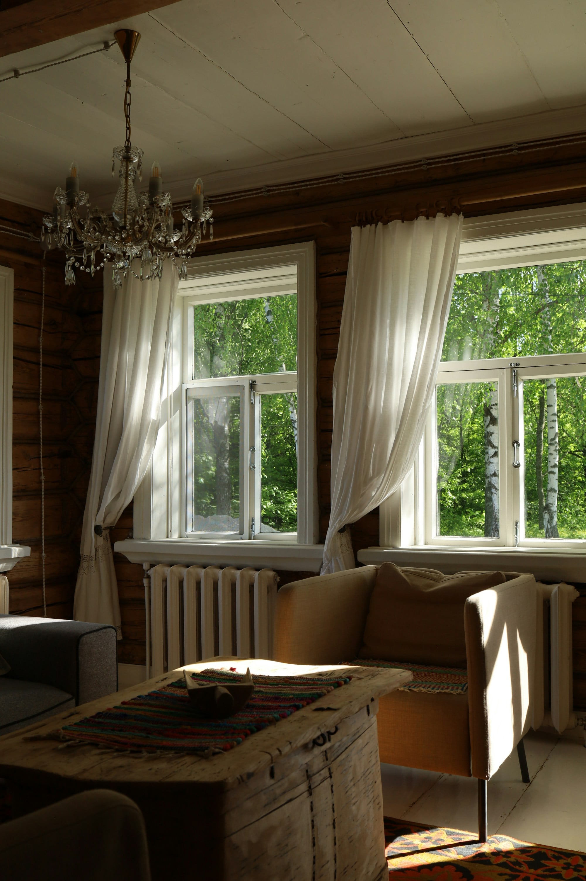 A sunlit cottage sitting room with large windows