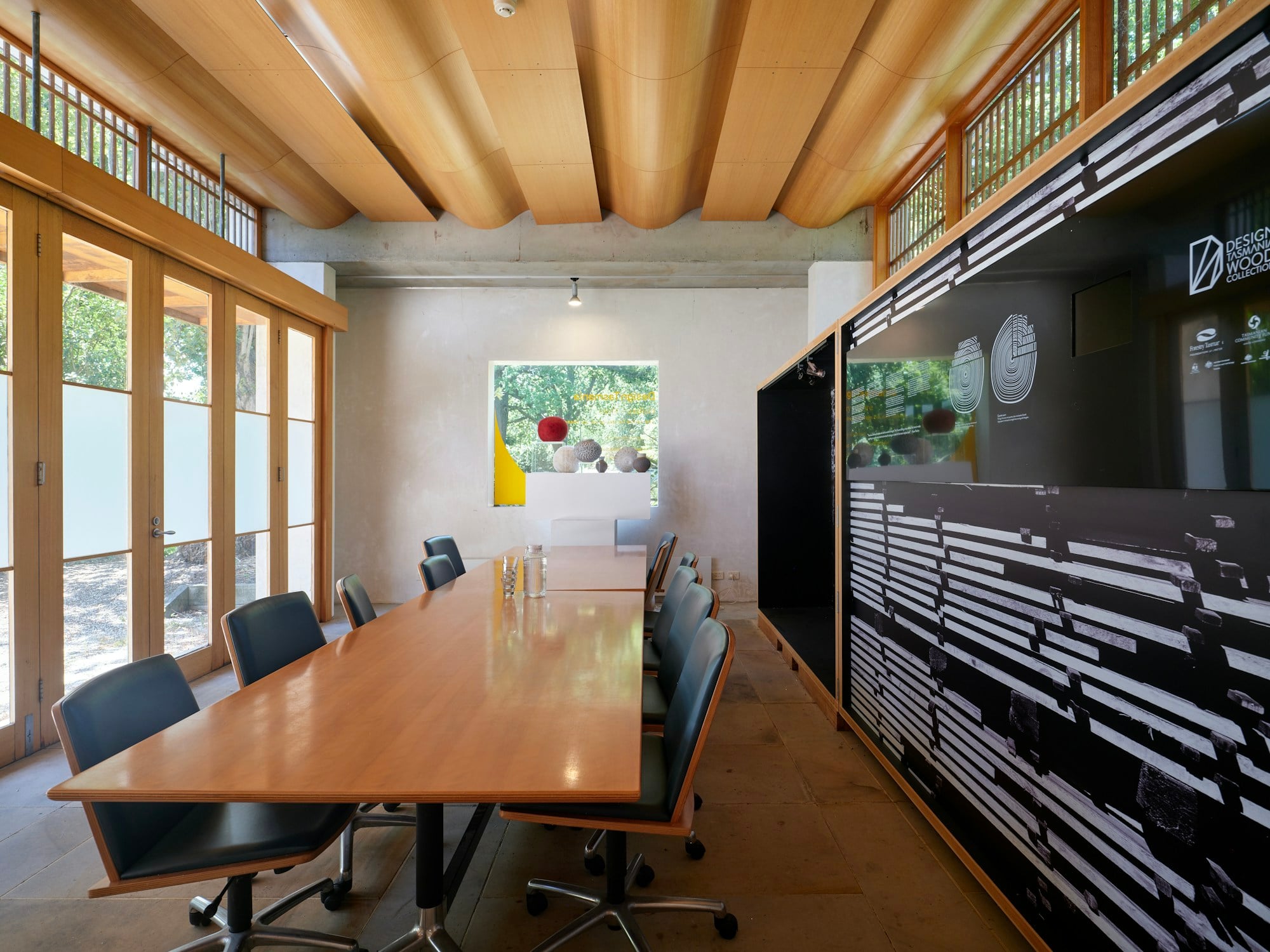 A sunlit meeting room with a long wooden table